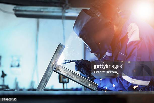 welder in factory welding steel construction for new machine - svetsare bildbanksfoton och bilder