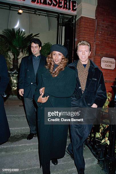 English singer-songwriter David Bowie and his wife, Iman, leaving the Bombay Brasserie in South Kensington, London, 21st November 1993.
