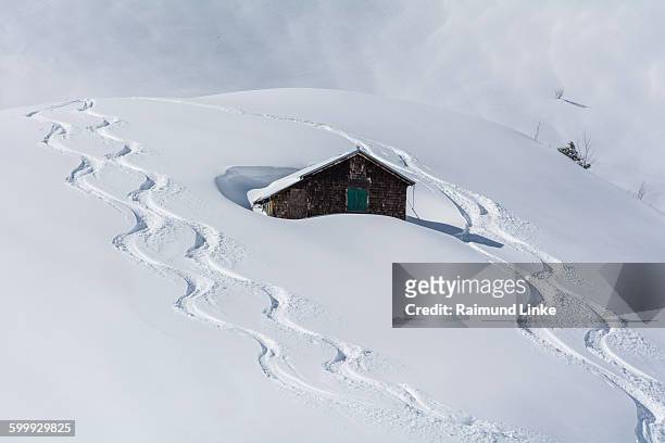 mountain cabin with ski tracks in deep snow - oberstdorf stock-fotos und bilder
