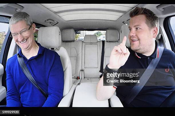Tim Cook, chief executive officer of Apple Inc., left, is seen on screen smiling in a car with comedian James Corden during an event in San...