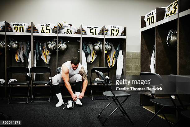 football player in locker room preparing for game - professional sportsperson stock pictures, royalty-free photos & images