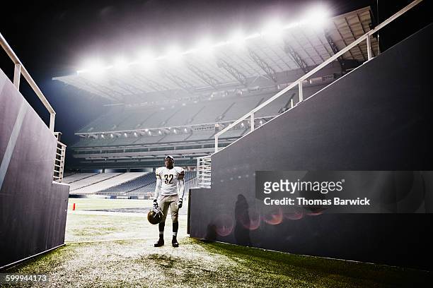 football player standing at end of stadium tunnel - professional sportsperson stock pictures, royalty-free photos & images