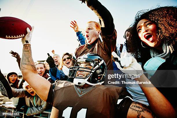 quarterback celebrating touchdown with fans - drive ball sports stock-fotos und bilder