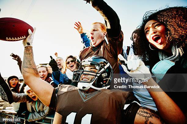 quarterback celebrating touchdown with fans - football américain femme photos et images de collection