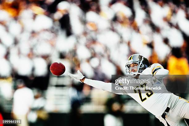 football receiver diving for catch during game - american football game stockfoto's en -beelden