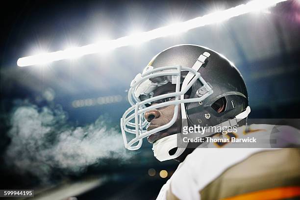 football player wearing helmet standing on field - protective sportswear stock pictures, royalty-free photos & images
