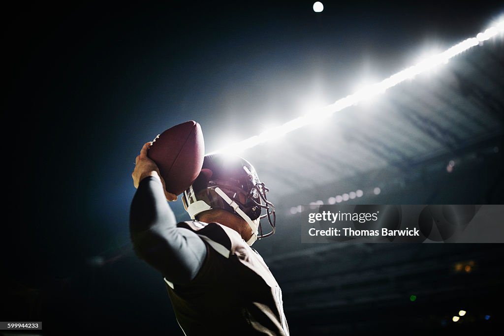 Quarterback preparing to throw pass at night