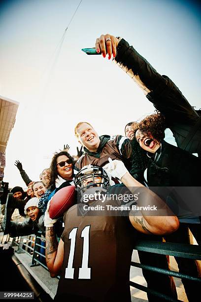football fans taking selfie with football player - football phone stock pictures, royalty-free photos & images