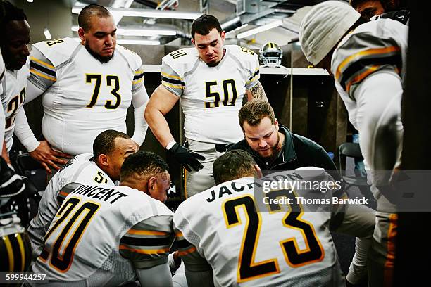 football players with coach reviewing plays - washington state public stadium authority stock pictures, royalty-free photos & images