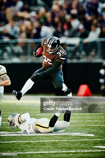 football running back leaping over tackler - rush american football stock pictures, royalty-free photos & images