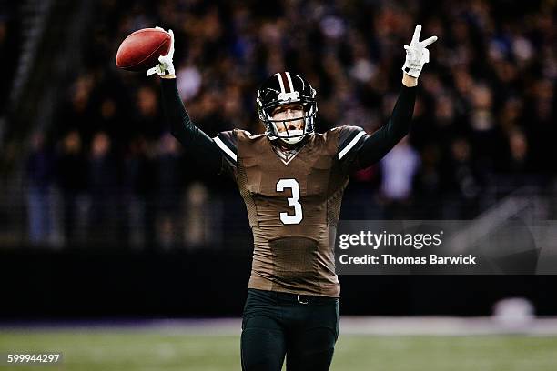 football quarterback celebrating on field - football spieler stock-fotos und bilder
