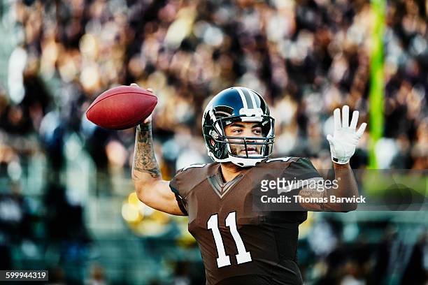 football quarterback preparing to throw pass - quarterback stock-fotos und bilder