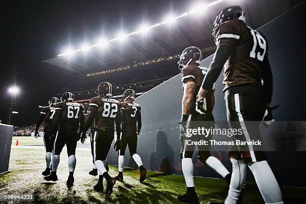 football team walking out of stadium tunnel - mannschafts wettbewerb stock-fotos und bilder