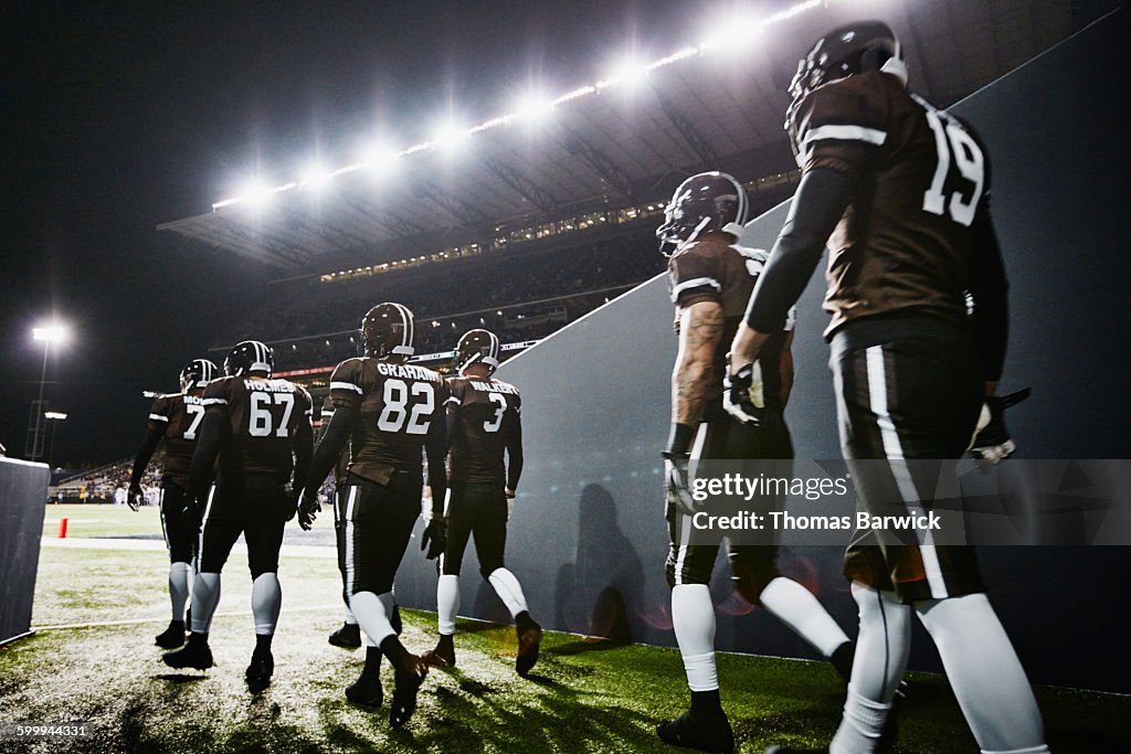 Football team walking out of stadium tunnel