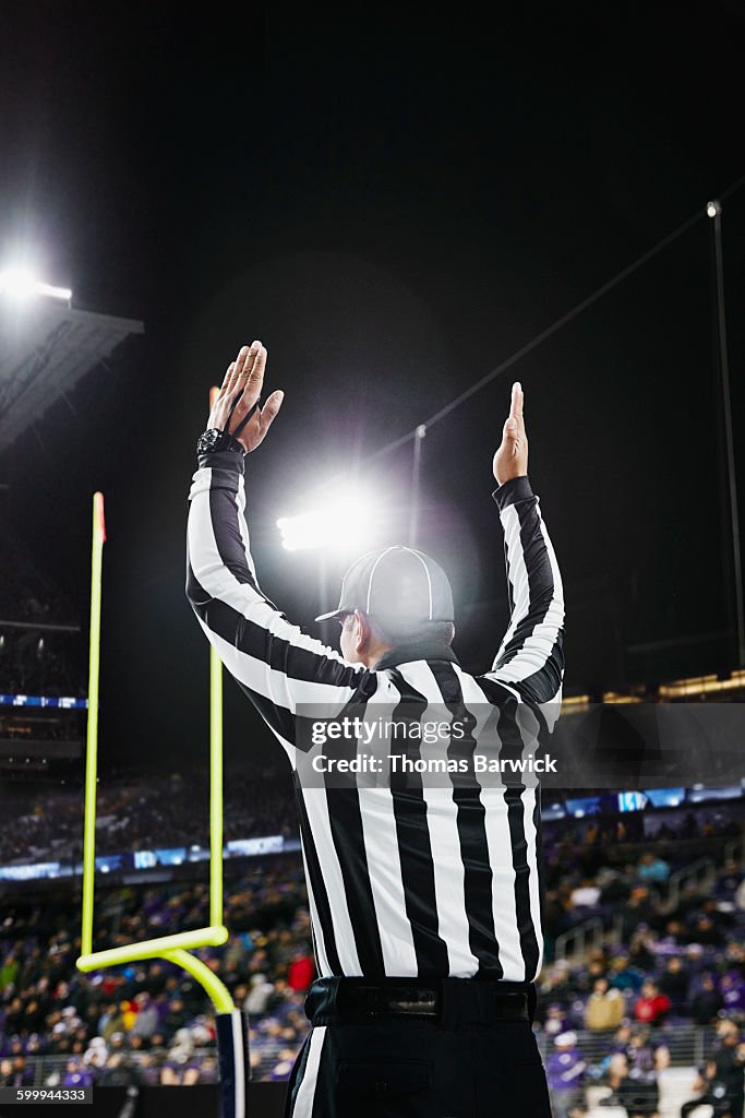 Referee signaling touchdown on field during game