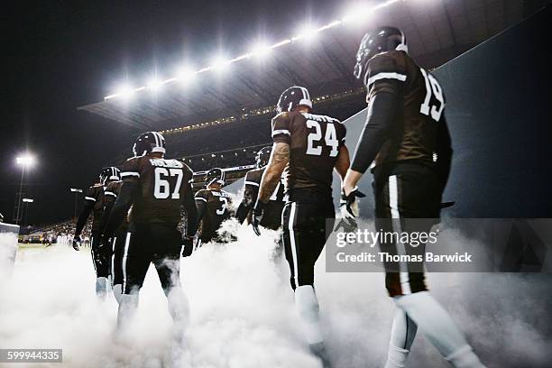 football team walking out of stadium tunnel - futbol americano fotografías e imágenes de stock