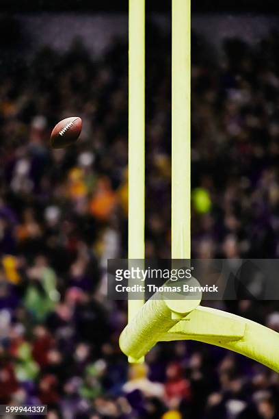 football flying through goal posts in stadium - but de football américain photos et images de collection