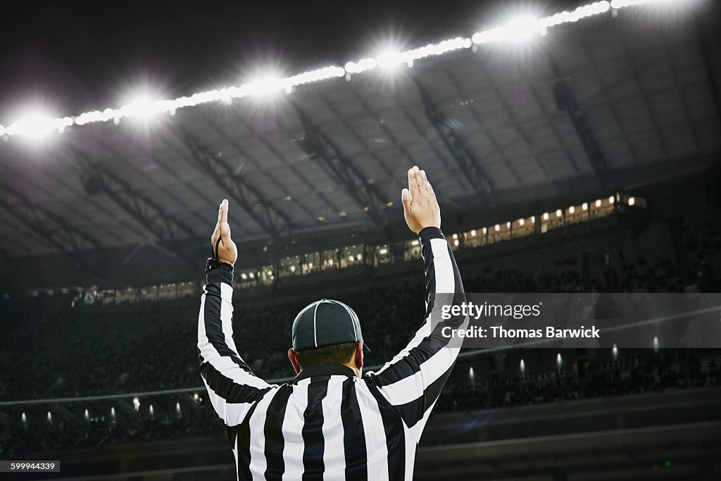 Football referee signaling touchdown in stadium