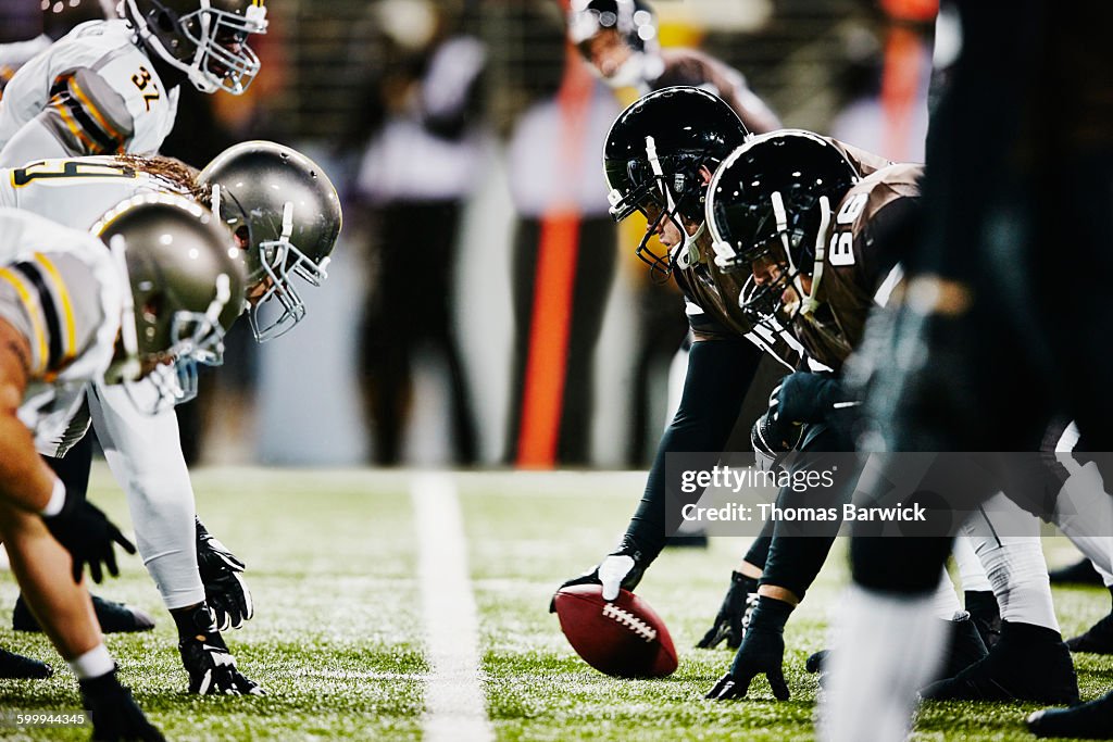 Football teams on line of scrimmage in stadium