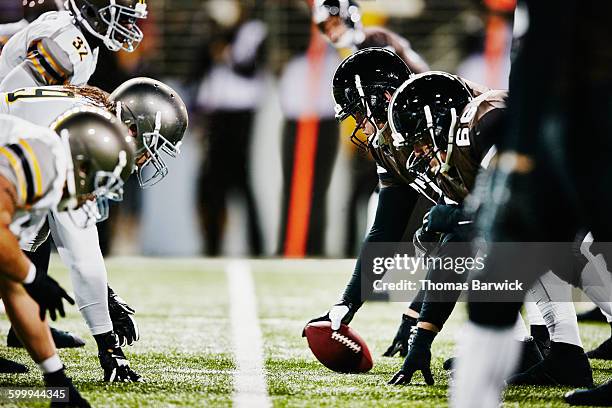 football teams on line of scrimmage in stadium - american football player stockfoto's en -beelden