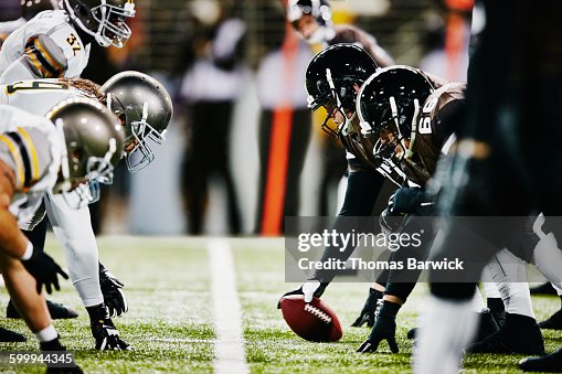 Football teams on line of scrimmage in stadium Football teams on line of scrimmage in stadium