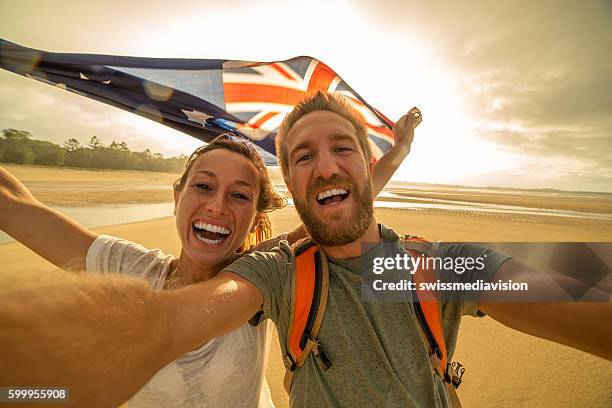 young couple on beach take selfie portrait with australian flag - australia day stock pictures, royalty-free photos & images
