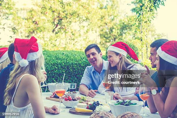 group of people celebrating with santa hats. - restaurant sydney outside stock pictures, royalty-free photos & images