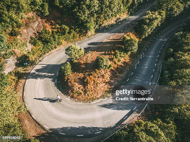 overhead view of a woman on solo bicycle road trip - aerial mountain pass imagens e fotografias de stock