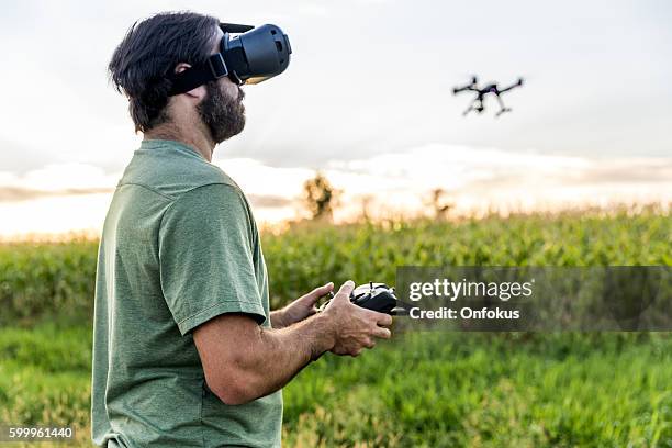 バーチャルリアリティゴーグルヘッドセットでドローンを飛ばす男 - flying goggles ストックフォトと画像