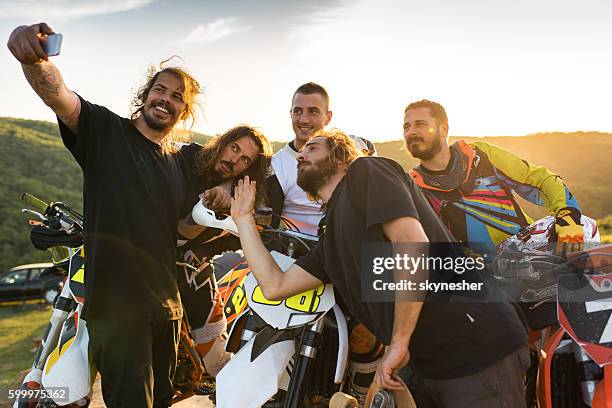 team von motocross-fahrern, die spaß haben und selfies machen. - motorradfahrer stock-fotos und bilder