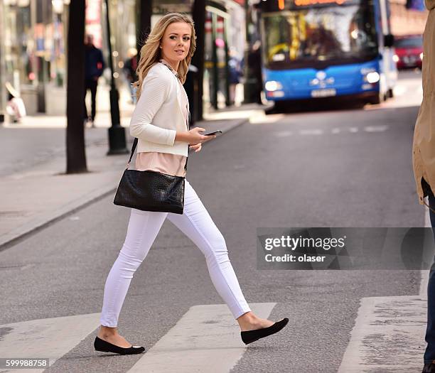 mujer cruzando calle, paso de cebra, autobús y tráfico de fondo - paso de cebra fotografías e imágenes de stock