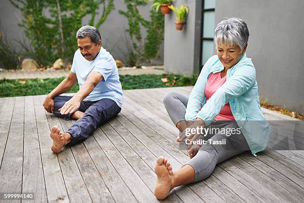 verbesserung ihrer lebensqualität nacheinander - senior yoga stock-fotos und bilder