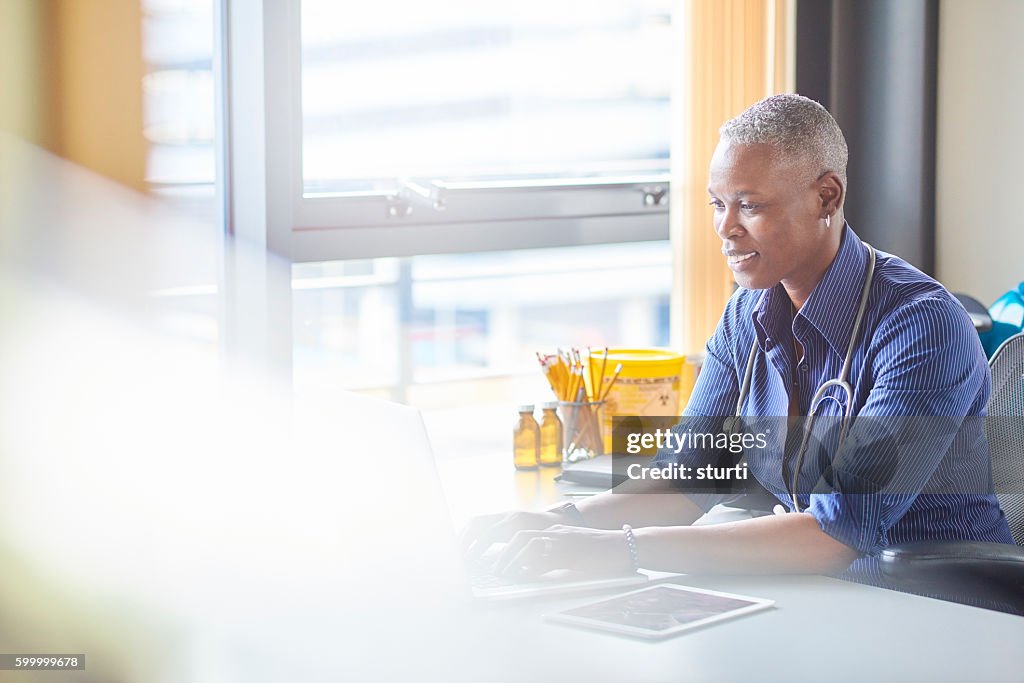 Smiling female doctor sitting at her desk