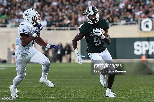 Donnie Corley of the Michigan State Spartans is pursued by Thomas Brown of the Furman Paladins during the first half of a game at Spartan Stadium on...