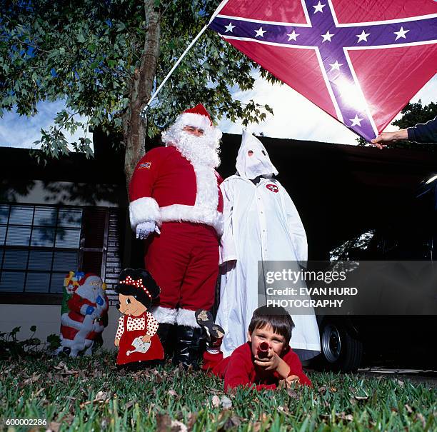 Members of Ku Klux Klan posing with Santa Claus, Klan Claus and child.