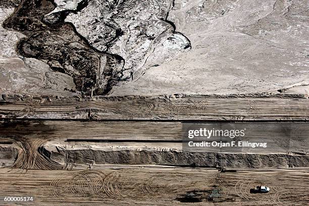 Pick up truck passes a tailings pond at the Syncrude open pit oil excavation mine in Fort McMurray. The tailings ponds are areas of refused mining...