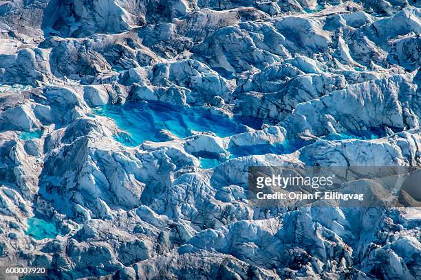 Ponds of water from melting ice at the Knik Glacier in Alaska. Lack of snow-cover expose the ash fallout from the nearby Redoubt Volcano, reducing...