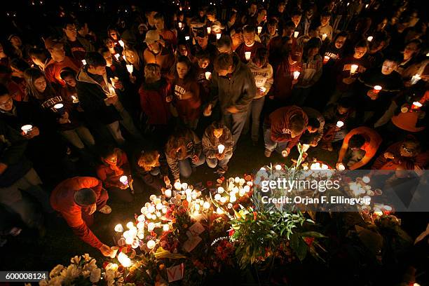 Students, faculty, relatives and neighbors hold a candlelight vigil outside the Burruss Hall at Virginia Tech, in Blacksburg.