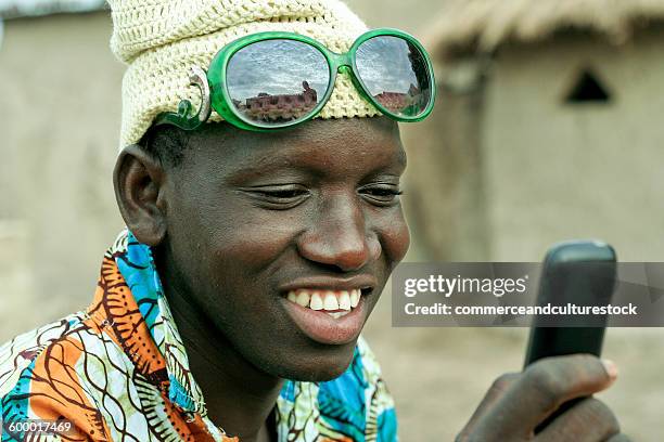 young villager enjoying with a mobile phone - commerceandculturestock stock pictures, royalty-free photos & images