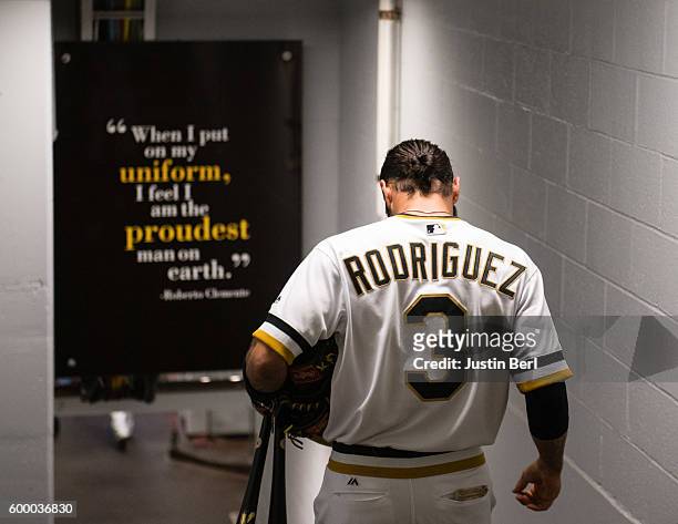 Sean Rodriguez of the Pittsburgh Pirates walks past a sign honoring Roberto Clemente as he heads to the dugout before the start of the game against...