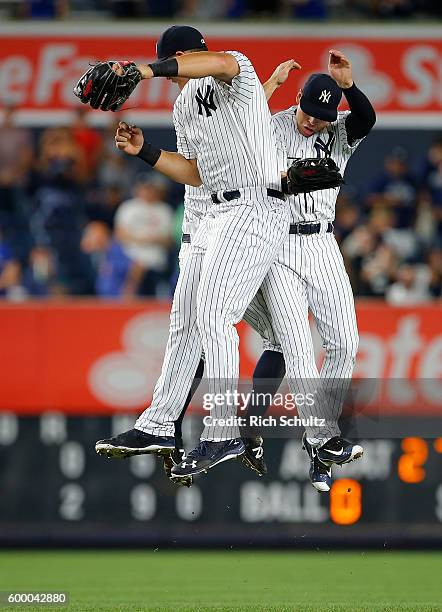 Outfielders Aaron Judge, Brett Gardner and Jacoby Ellsbury of the New York Yankees jump to celebrate their 2-0 win over the Toronto Blue Jays in a...