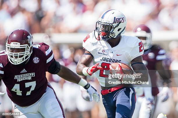 Running back Xavier Johnson of the South Alabama Jaguars looks to maneuver by defensive lineman A.J. Jefferson of the Mississippi State Bulldogs at...