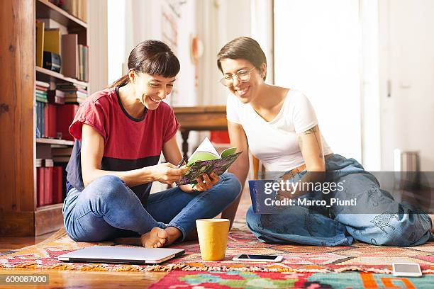 two young women relaxing at home enjoying free time - cool couple in apartment stock pictures, royalty-free photos & images