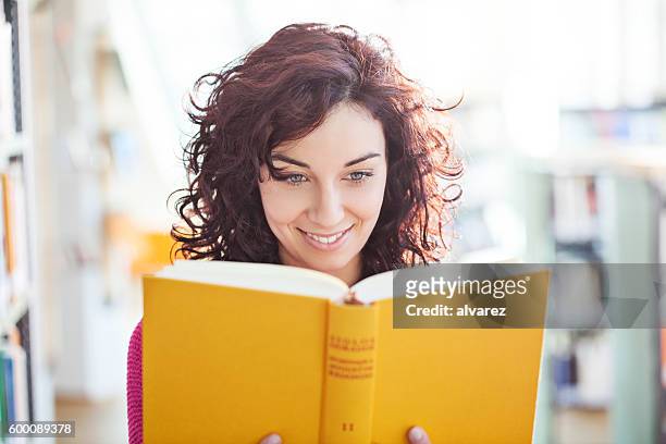junge frauen lesen ein buch in der bibliothek - library　woman stock-fotos und bilder