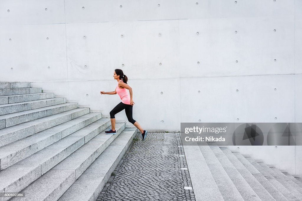 Femme monter les marches dans un cadre urbain