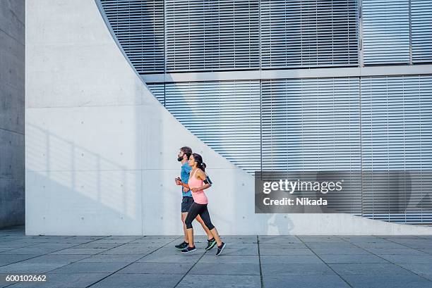 young friends running in front of wall - center athlete stock pictures, royalty-free photos & images