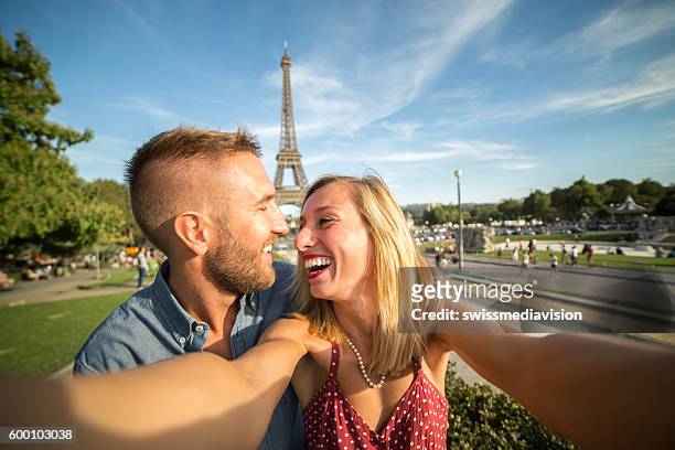 junges paar fängt romantische tormomente ein - couple paris tour eiffel trocadero stock-fotos und bilder