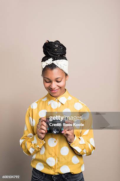 Portrait of a young woman holding old camera