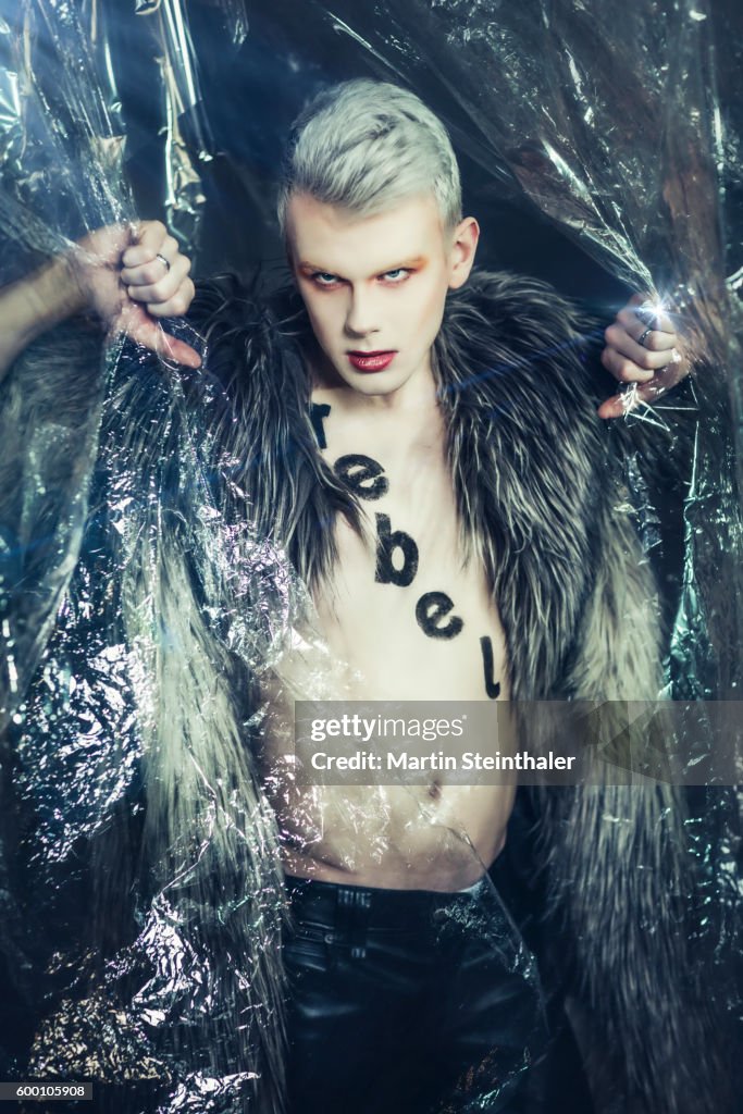 Blond androgynous man in fake fur - in provocative position