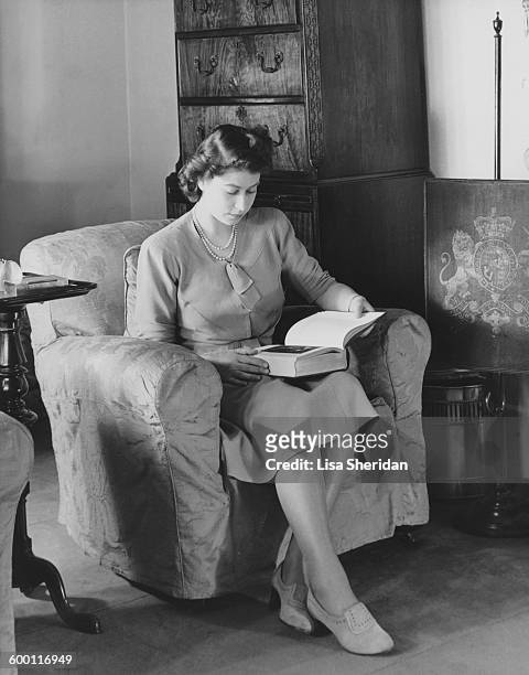 Princess Elizabeth reading in her sitting room in Buckingham Palace, London, 19th July 1946.
